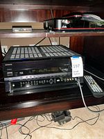 Receiver and remote shown together on shelf, Dish network box visible above