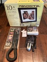 Photo showing all items including photo frame box, Black & Decker snake light flashlight in packaging, Samsung MP3 player box, Kensington wireless mouse with USB receiver.