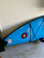 Front third of blue paddleboard with Sunsai logo and bungee cord straps
