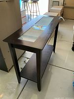 Wood coffee side table with rectangular shape and glass inset top panel, dark espresso brown finish, showing two glass panels on top and lower shelf.