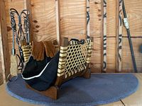 Full set of hearth items displayed on a blue wool hearth rug featuring the wrought iron stand with tools, firewood holder, tote, and gloves.