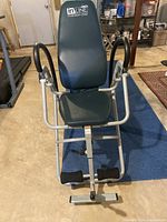 Front view of the Stamina inLINE inversion chair showing padded seat, backrest, and foot support.