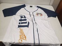 Front view showing Miller Lite logo, button placket, navy raglan sleeves, tag visible