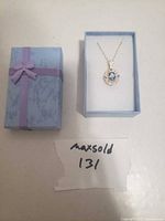 Necklace in open box alongside closed box