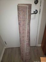Rolled rug standing upright against door