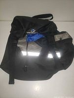 Front of Voyager pannier showing logo, reflective strip, straps, and drawstring top