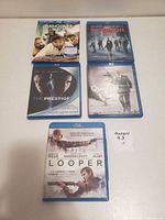 Front view of five Blu-ray cases: Hangover Part II, Inception, The Prestige, Quantum of Solace, Looper