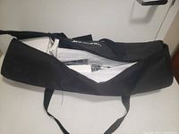 Closed black nylon carry bag partially unzipped showing kit contents