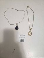 Both necklaces laid flat to show pendants and chains