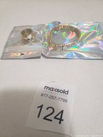 Bracelet and ring in sealed holographic pouches with lot number card visible