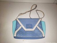 Front view showing patterned envelope flap, white trim, strap detail