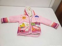Front view of pink hooded sweater with zipper and embroidered animals