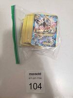 Stack of Pokémon cards in zip bag with Japanese Tag Team GX card visible on top