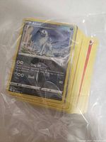 Stack of Pokémon cards in plastic bag, front card Absol visible