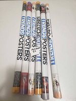 Seven sealed poster tubes showing full length and branding