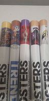 Five sealed poster tubes with visible labels and graphics