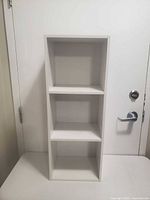 Front view showing three-shelf white bookcase