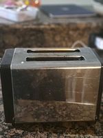 Photo showing the vintage chrome 2-slice toaster with visible wear and two slots on top.