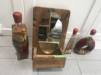 Front view of all three vegetable bottles and wooden mirror with box