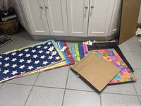 Stack of assorted extra-large gift bags on floor showing variety of designs