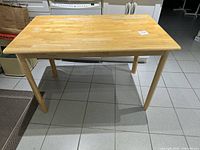 Full view of light pine dinette table front angle