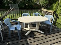 Full view of oval patio table with four chairs on deck