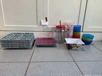 group of stacked plates, bowls and drinkware on floor