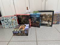 Five puzzle boxes standing upright plus one lying flat showing front artwork