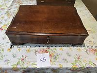 Closed wooden chest showing overall appearance and tape measure for size