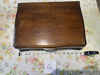 Top view of closed wooden chest with tape measure for scale