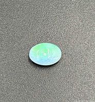 Light green and blue oval opal gemstone on black background