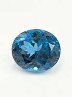 Close-up, top-down view of the oval-shaped deep blue spinel gemstone highlighting the symmetrical facets and polished surface.