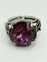 Front view of round faceted amethyst set in 4-prong sterling silver adjustable band with scroll detail