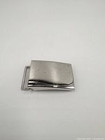 Top view of sterling silver belt buckle showing smooth curved surface and light tarnish spots.