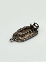 Sterling silver boat charm showing detailed boat structure from an elevated angle.