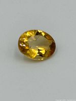 Top view of the oval yellow faceted topaz gemstone showing facets and clarity.