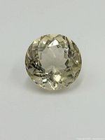 Close-up photo of round-cut light yellow Topaz gemstone showing top facets and color