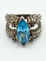 Front view showing the marquise-cut blue topaz set in sterling silver with detailed band design.