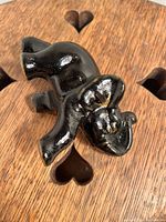 Front angle of a small glossy black elephant figurine with visible gold paint details on ear and eye.