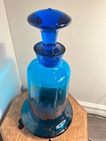 Image showing the blue glass decanter with stopper on top, highlighting its shape and color.