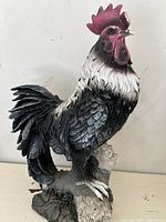 Side view of the vintage resin rooster garden statue showing detailed feathers and base.
