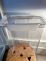 Clear plastic kitchen storage container with snap-lock lid seen from front angle