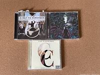Front view of three A Day to Remember CDs: What Separates Me From You, Homesick, Common Courtesy albums.