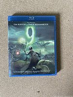 Front cover of Blu-Ray DVD titled '9', showing animated movie artwork with character holding a glowing object.