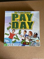 Box cover of the Pay Day Classic Edition board game with colorful logo and illustration of people waving money.
