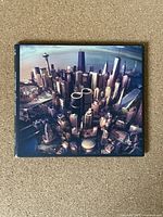 Front cover of the Foo Fighters Sonic Highways CD album showing a detailed cityscape image of a skyline with skyscrapers.