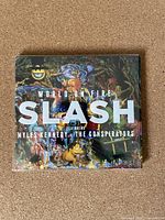 Front cover of the Slash 'World on Fire' CD in jewel case with detailed artwork and album title.