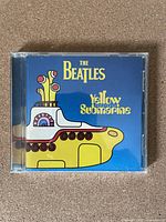 Front cover of The Beatles Yellow Submarine CD album showing illustrated yellow submarine on blue background