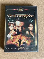Front cover of GoldenEye MGM Special Edition DVD case showing Pierce Brosnan with gun and female characters.