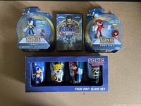 Photo showing the full Sonic collection lot with action figures, DVD and four pint glasses